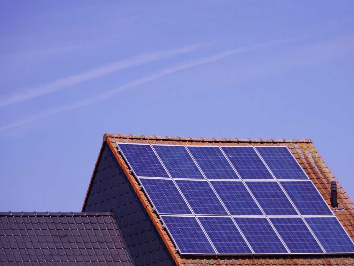 Solaranlage auf einem Giebeldach vor blauem Himmel