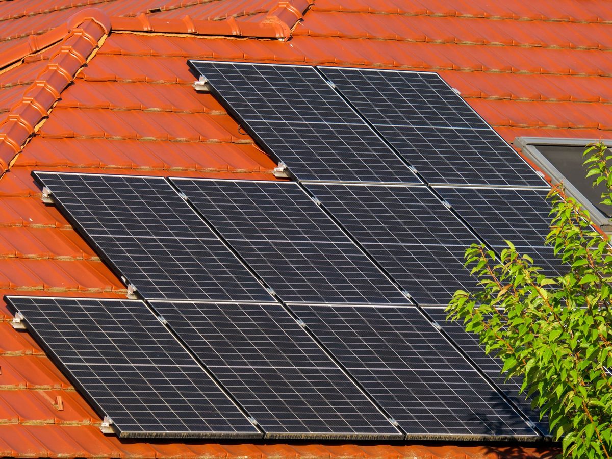 Dunkle Solarmodule auf rotem Ziegeldach