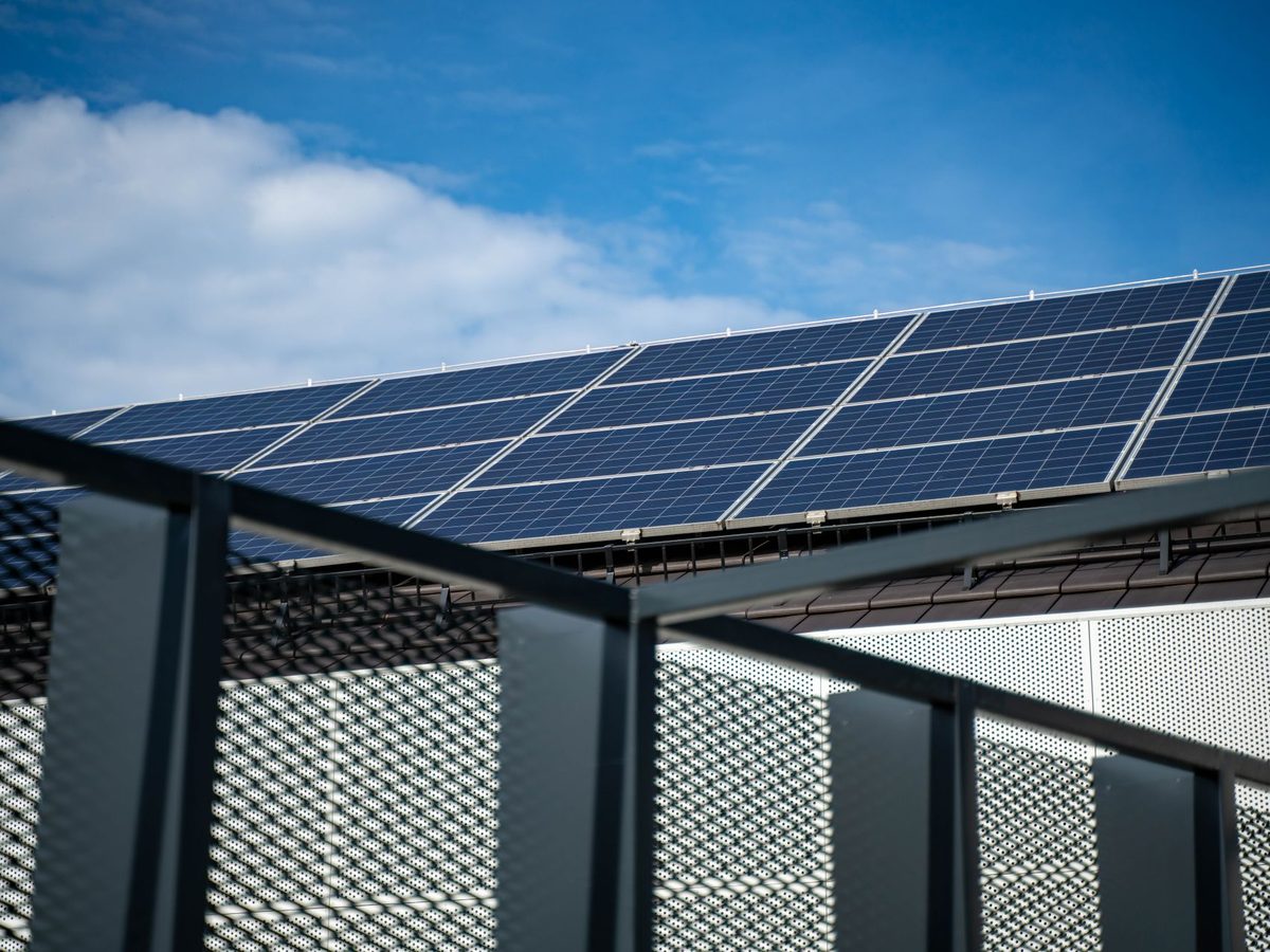 Solarmodule auf einem modernen Dach vor blauem Himmel